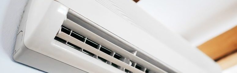 White air conditioning unit mounted onto a white wall