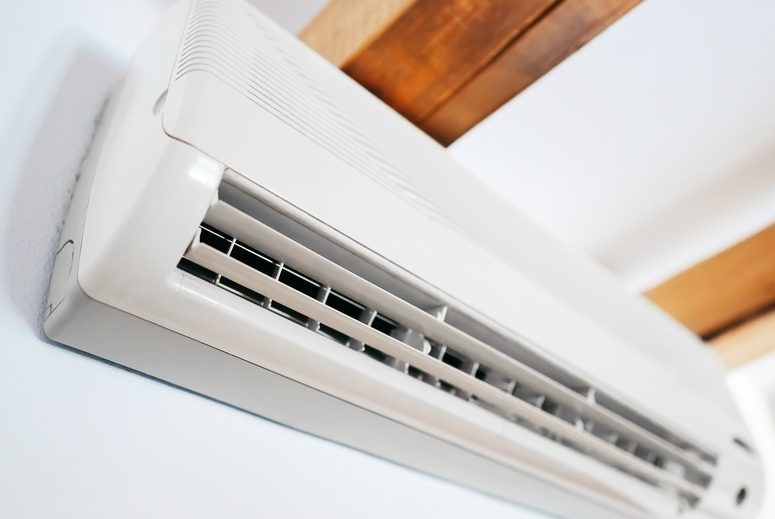 White air conditioning unit mounted onto a white wall