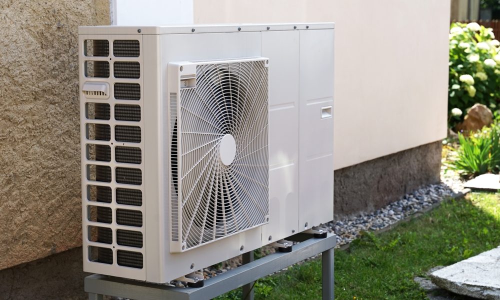 heat pump in garden against wall